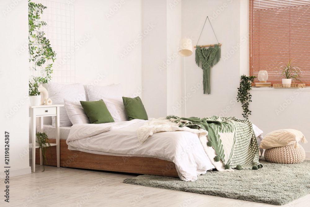 Fototapeta premium Interior of bedroom with table, pouf and green plants