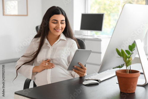 Pregnant businesswoman work...