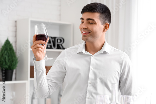 Young sommelier with glass ...