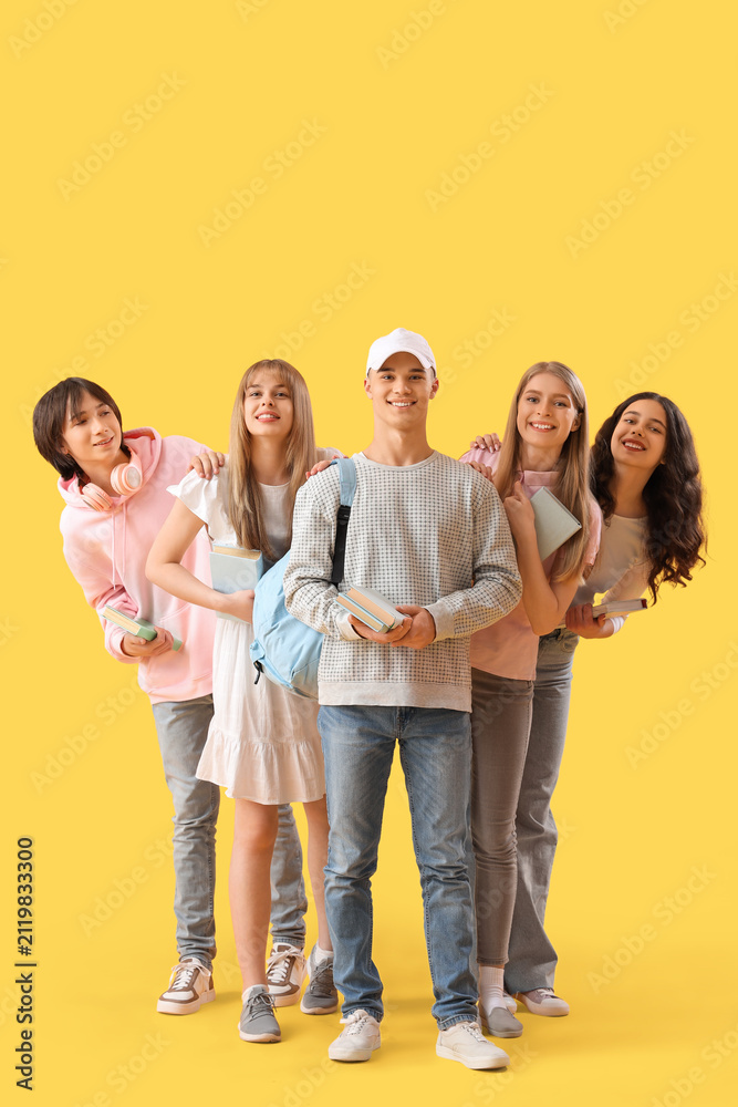 Obraz premium Group of students with books on yellow background