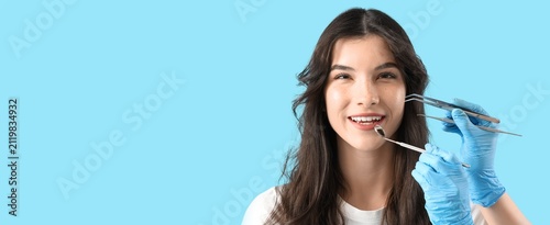 Foto Smiling young woman with dental mirror and tools, oral hygiene and dental care c