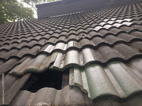 The damaged terracotta roof tiles on the exterior of the building are awaiting repair.