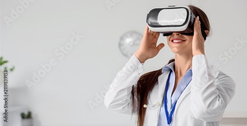Female doctor in a white coat wearing virtual reality glasses for medical tra...