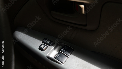Fotografie Close up view of a car interior door panel featuring power window switches and a door lock control button