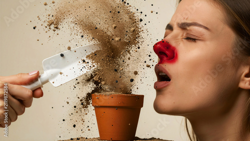 Young woman with red nose reacts to soil dust cloud. Person experiencing allergic reaction while gardening with small pot. Healthcare allergy concept for antihistamine marketing campaigns.