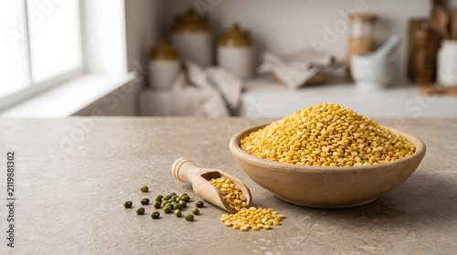 Yellow split peas in rustic bowl with wooden scoop on kitchen counter with copy space