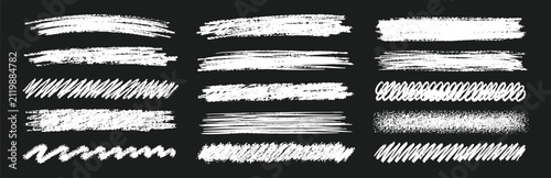 Fotografie A collection of hand-drawn chalk brush strokes and textures on a black background