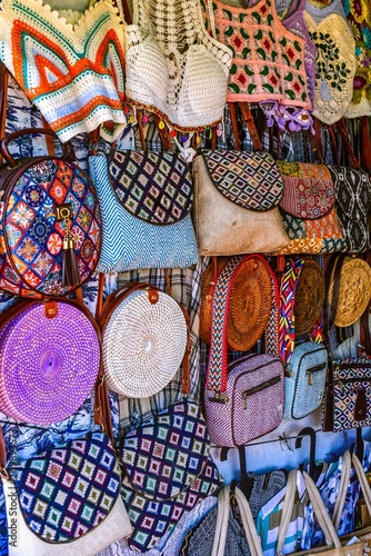 A vibrant display of handmade bags, crochet purses, and woven fashion accessories at a souvenir shop in Varkala, Kerala, highlighting locally crafted products inspired by traditional Indian artistry