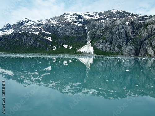 Photography Snow-capped mountains reflected in calm water at Glacier Bay National Park, Alas