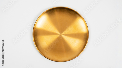 A gold-colored porcelain plate, a plate of food, against a white background.