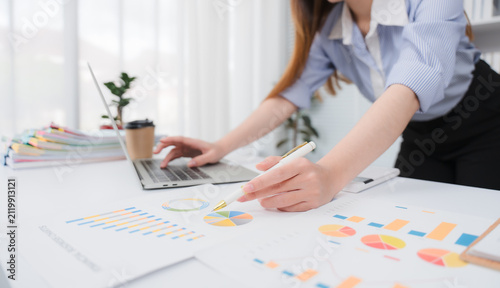 Business team jointly plan the investment at the meeting. Close-up of a business advisor pointing to graph and chart that analyze financial report, income statement, and company growth.	