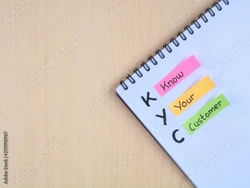 KYC (Know Your Customer) with colorful adhesive notes on wooden table. Representing business strategy, identity verification, compliance regulations, client relationship, and audience research