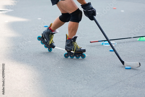 A middle-aged man's legs as he practices various roller skating maneuvers on an asphalt rink.