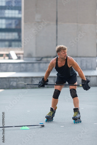 Vertical photo of a middle-aged man having a little break after practices hockey stick techniques.