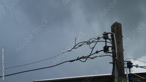 Fotografie The image features a close up of a utility pole with multiple electrical wires attached to it