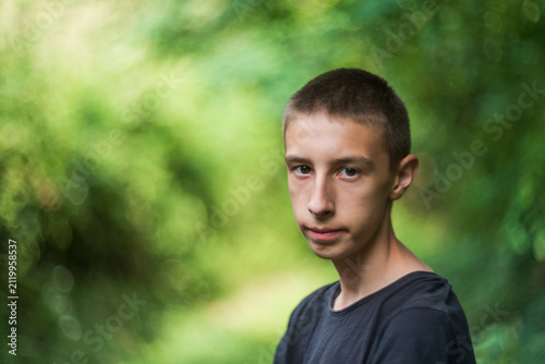 Portrait of a smiling 15-year-old teenage boy outdoors in an urban setting