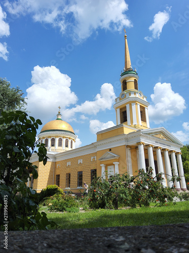Exterior facade of Transfiguration Cathedral in classicism style with white columns and golden dome under blue sky in Dnipro, Ukraine.