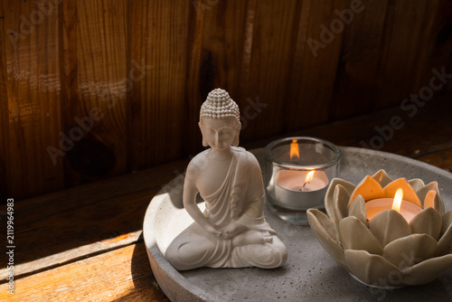 фотографія White Buddha statue with burning candles and sage smudge stick for meditation an