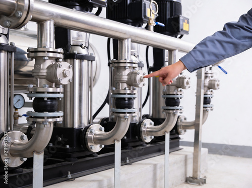 Фотография Engineer's hand adjusting valve on industrial pump system for optimal performanc