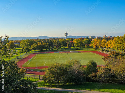Aerial view of a European city with autumn trees and mountains.
