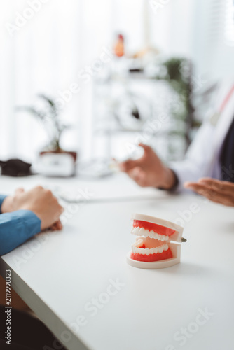 Foto Dentist explaining dental treatment to a patient in a modern office, clearly sho