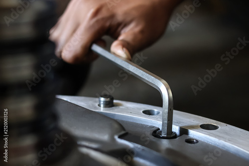 Quadro su tela Close up of a mechanic using an allen key to assemble an industrial machine component