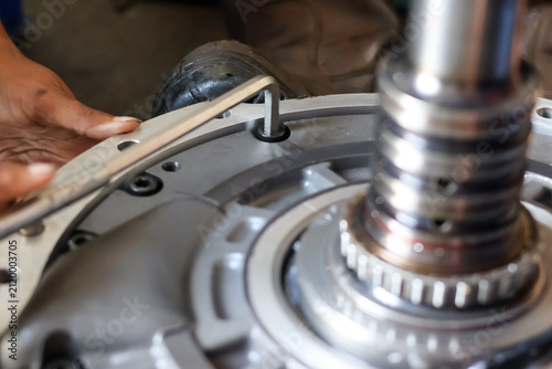 Obraz na płótnie Close up of a mechanic using an allen key to assemble an industrial machine component