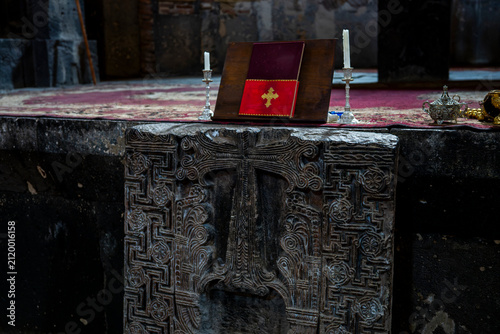 Carved Stone Khachkar in Ancient Church Altar with Holy Book and Candles