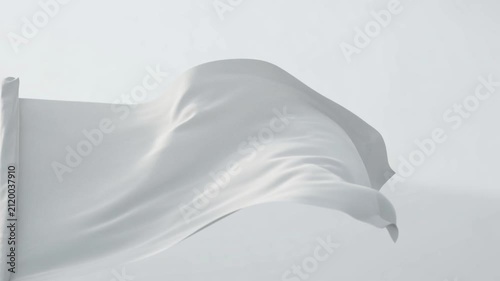 White flag waving in the wind against a clear light sky symbolizing surrender, peace, truce, or a clean minimalist canvas