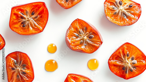 Bright orange fruit halves with seeds and juice drops on white. Fresh, vibrant, and healthy food background.