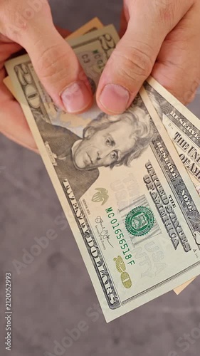 Vertical video. United States Dollar Banknotes Magically Disappearing One by One From Both Hands Until Nothing Remains, Top Down View, Financial Loss, Vanishing Wealth