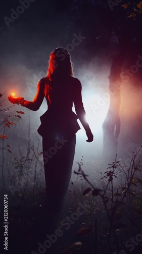 fantasy woman walking in dark dusk night misty forest full fog, Mystical sexy girl back rear view, hand holding glowing ball red orange light magic fire flower. Gothic Lady black long dress. art vedeo