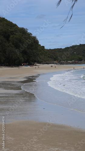 Photography The image depicts a serene beach scene with gentle waves reaching the sandy shore