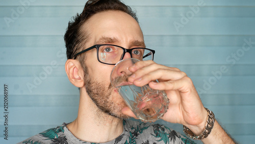 Cuadro en lienzo Mid-adult man in glasses drinking a glass of pure water