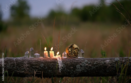 Fotografie quartz crystals, moon amulet and burning candles outdoor, abstract dark natural background