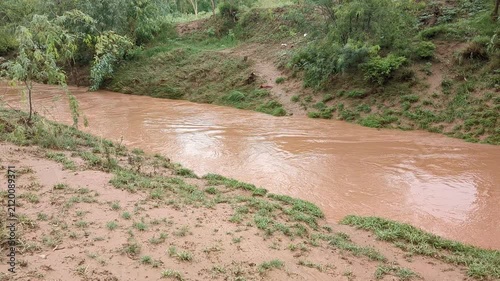 Muddy Rainwater Flowing Through Seasonal Stream in Rural Landscape After Heavy Rain