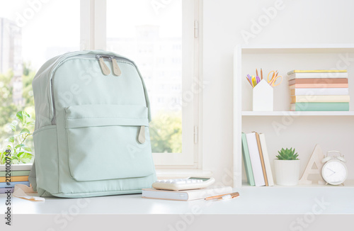 Study desk with notebooks and backpack on home window view background