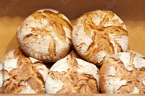 Freshly Baked Round Artisan Sourdough Bread Loaves Displayed in Bakery Shelf