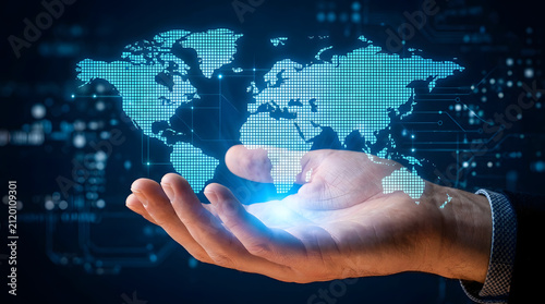 Holographic globe displayed in hand for global digital connectivity concept with hand holding glowing holographic world map against futuristic digital network background