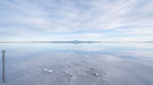 Salt flat reflection at horizon. Mirror effect on water surface with clear blue sky.
