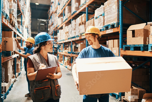 Warehouse workers discussing inventory in distribution aisle