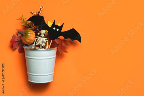Top view of white metal cube with pumpkins,autumn leaves,Halloween bat and space for text. Halloween concept background