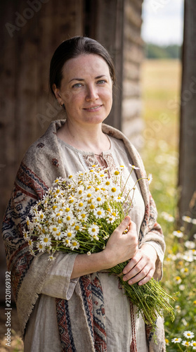 An adult village woman with a bouquet of wild flowers