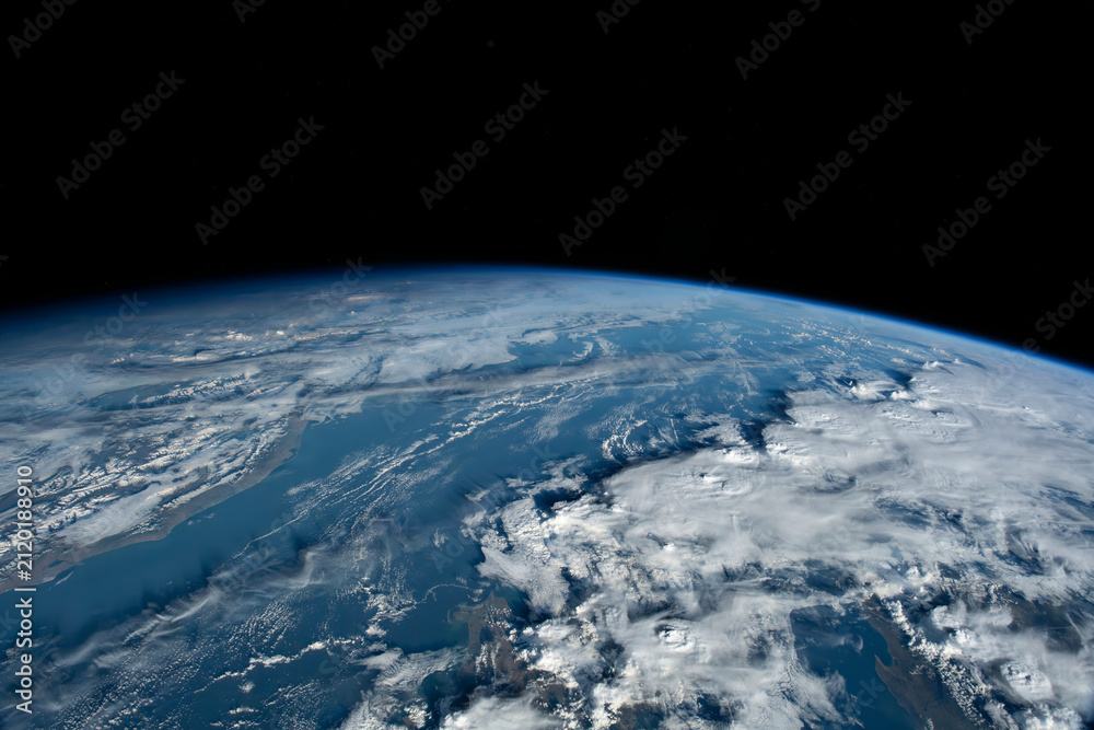 Fototapeta premium Earth from orbit showing atmosphere and vast cloud formations over ocean.