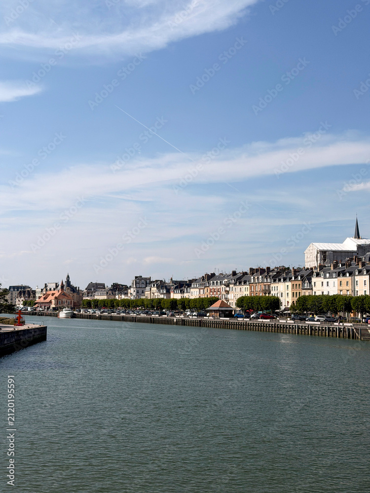 Obraz premium View of the historic harbor and traditional buildings in Trouville-sur-Mer, France, along the canal on a sunny day.