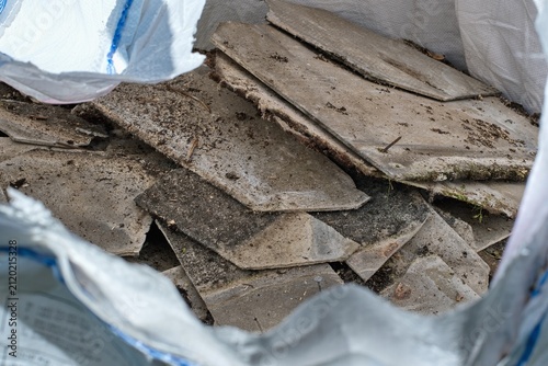 Building  material with asbestos fibres collected in asbestos disposal bag. Health harmful and hazards effects.