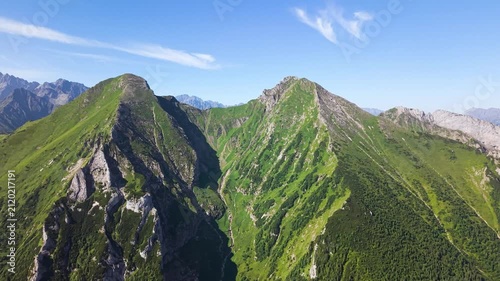 Aerial footage of the Belianske Tatry in Slovakia, featuring the mountain peaks Zdiarska Vidla and Havran. The view captures the dramatic ridgelines, rocky slopes and green alpine landscape