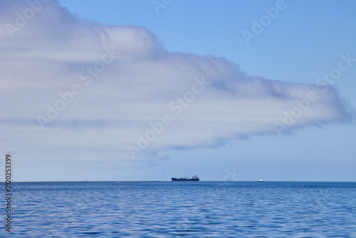 фотографія Ein Schiff liegt auf ruhigem Wasser unter einer ausgedehnten Wolkenbank in Walvis Bay in der Region Erongo, Namibia