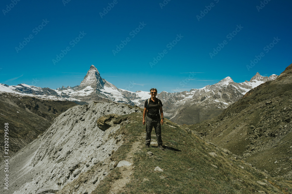 Fototapeta premium Hiker enjoying breathtaking zermatt mountain landscape under clear blue sky