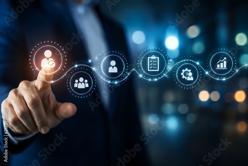 A businessman's finger activates a digital network of business process icons on a screen